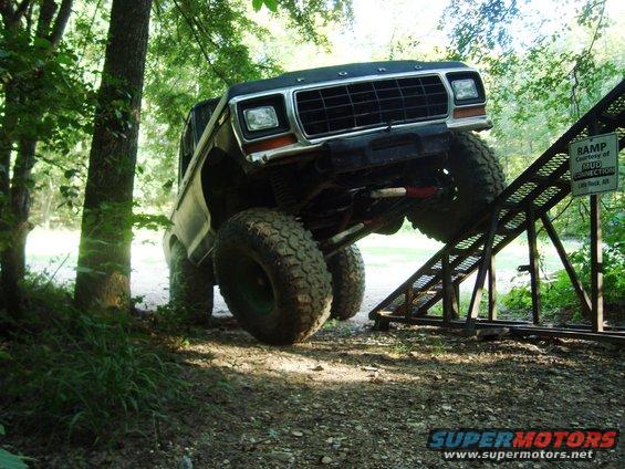 1979 Ford Bronco climbing a ramp, 3q-front view, black grille