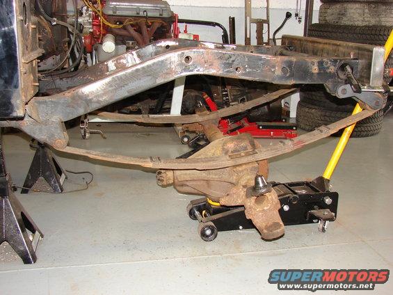 Vehicle frame and leaf spring suspension on jack stands with a floor jack under the rear axle