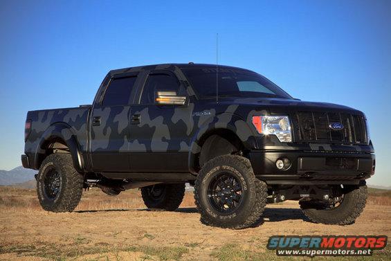 Black and grey camouflage Ford F-150 pickup truck, lifted with off-road tires