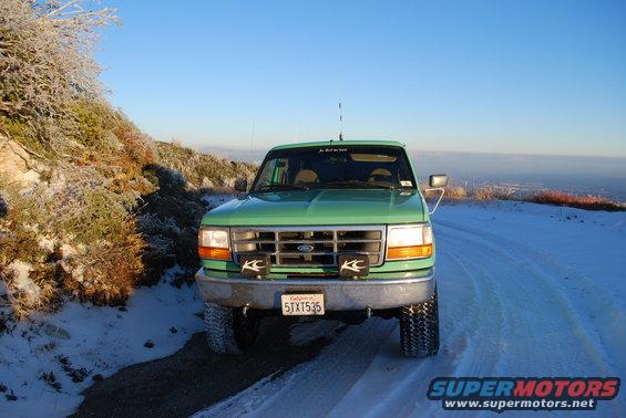 Green 1996 Ford Bronco front view in snowy landscape
