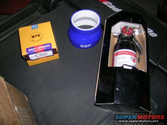 Yellow NPR box, blue GSP silicone coupler, and a boxed fire extinguisher on a dark textured surface