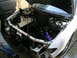 1993 Ford Probe - The front end of a white car has been disassembled, revealing the engine and its associated parts.