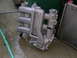 1993 Ford Probe - An aluminum intake manifold sits on a wet concrete surface beside a radiator.