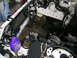 1993 Ford Probe - The engine bay of a vehicle is shown with the radiator and extensive wiring. Tools and a spray bottle are present.