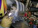 1993 Ford Probe - A person in a welding mask and gloves works on an intake manifold with various tools and supplies in the background.