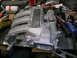1993 Ford Probe - An intake manifold with visible welding repairs sits on a workbench surrounded by tools and parts.