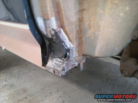 Vehicle rocker panel with rust damage and fresh welds, showing repair work