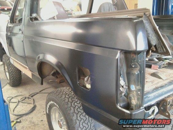Dark gray Ford Bronco rear quarter panel, missing taillight assembly, undergoing repairs