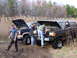 1985 Ford Bronco - Two men work on their off-road vehicles, a dark Bronco and a blue pickup, in a muddy field with dry reeds.