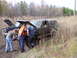 1985 Ford Bronco - Two vehicles are stuck in the mud, with three men looking under the hood of the lead vehicle.