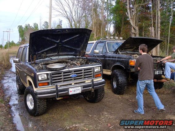 1985 Ford Bronco front view, hood open, in muddy terrain
