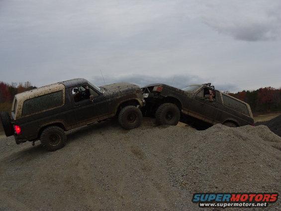 Two 1985 Ford Broncos climbing a gravel hill