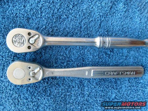 Two metal ratchets on a blue textured surface. The top ratchet has a circular emblem. The bottom ratchet has "CRAFTSMAN" imprinted on its handle