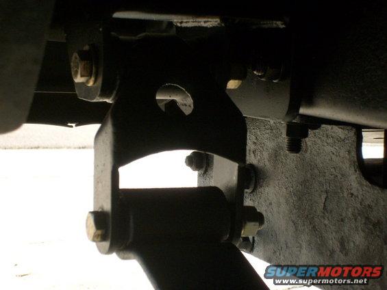 close-up of metal brackets and bolts on a vehicle's undercarriage
