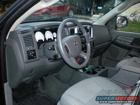 Interior view of a Dodge Ram pickup truck with a red vehicle visible outside
