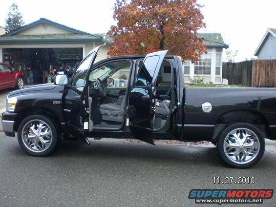 Black Dodge Ram pickup truck, 2007 model year, with all four doors open, parked in a driveway