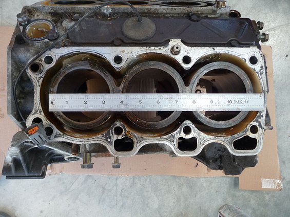 Engine block with a ruler measuring cylinder bore diameter. The ruler spans from about 1.5 to 10.5 inches