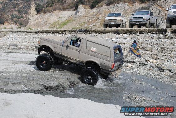 1996 Ford Bronco driving through water, lifted with large tires
