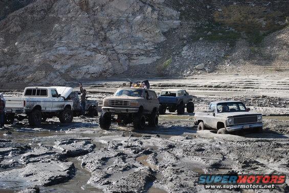 Tan Ford Bronco with lifted suspension stuck in mud, front view