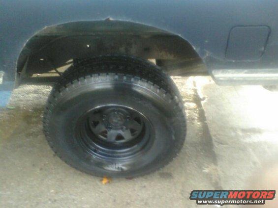 Rear wheel well and tire of a dark blue SUV
