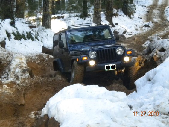 Dark blue 2005 Jeep Wrangler off-roading in snow and mud