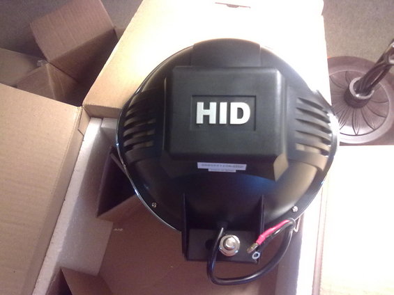 Black HID headlight assembly with 'HID' logo, wires attached, in cardboard box