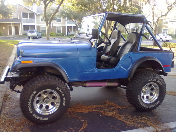 Blue 1978 Jeep CJ5 with black soft top, roll cage, and aftermarket wheels