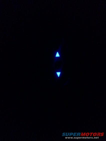 Two glowing blue arrow indicators, one pointing up, one down, on a dark surface