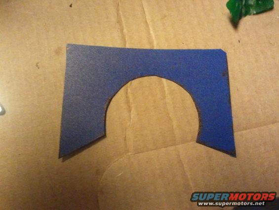 Blue gasket with semi-circular cutout on cardboard