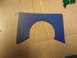 2003 Ford Crown Victoria - A blue gasket with a semi-circular cutout is shown on a cardboard surface, with a Supermotors.net watermark at the bottom right.