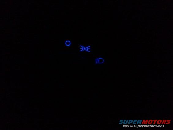 dashboard lights showing headlights, high beams, and a circular indicator
