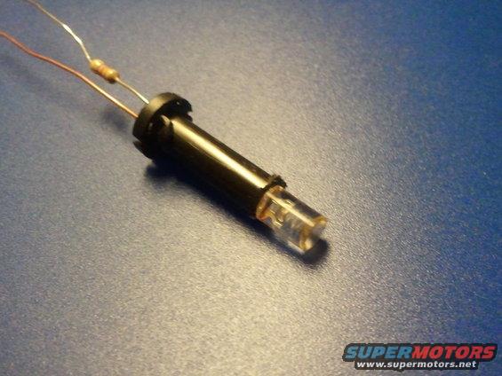 LED bulb with resistor and wires on blue surface