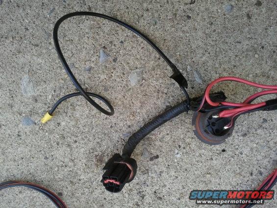 Headlight wiring harness with black and red wires and a black connector