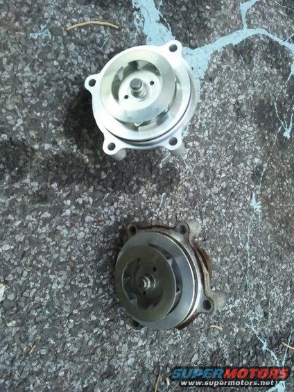 Two water pumps on asphalt, one new and one used