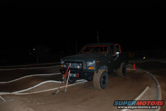 Dark green 1980s SUV with orange roll cage and off-road tires
