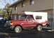 1995 Ford Bronco - This red 1995 Ford Bronco is equipped with a white camper shell, seen from a three-quarter front perspective.