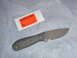 1991 Ford Bronco - A knife with a textured handle and a gray blade is shown next to an inspection sticker.