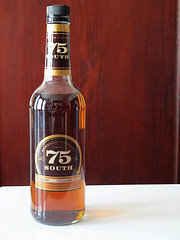 Bottle of 75 South whiskey with a black cap and gold label