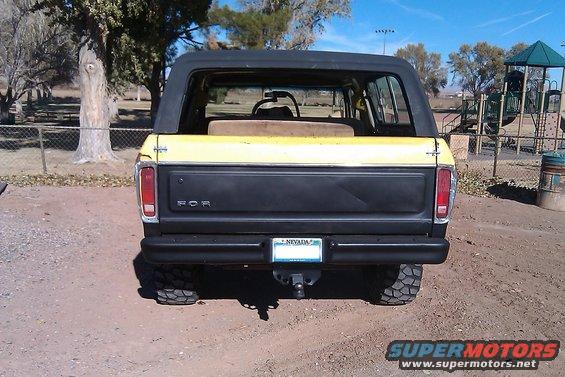 Rear view of yellow and black Ford Bronco with a black hardtop. Nevada license plate visible