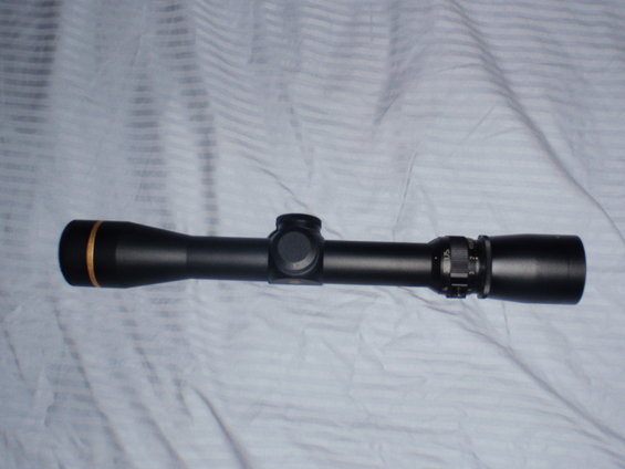 black rifle scope with gold ring on front lens cap