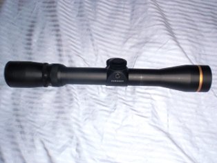 Black rifle scope with gold ring and visible branding