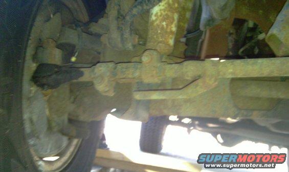 Undercarriage view of rusty suspension and tire
