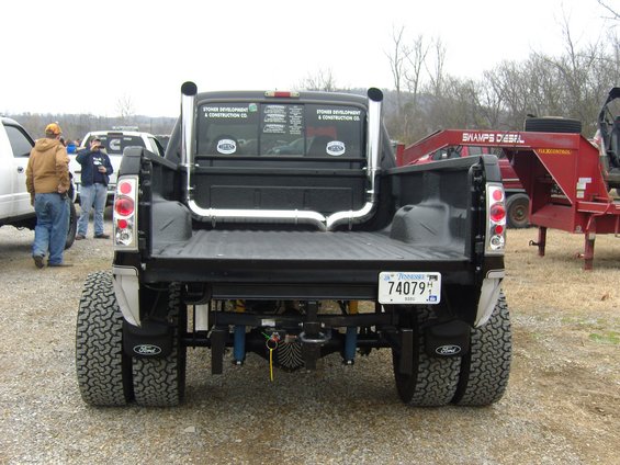 Black pickup truck with dual rear wheels, chrome exhaust stacks, and a Tennessee license plate