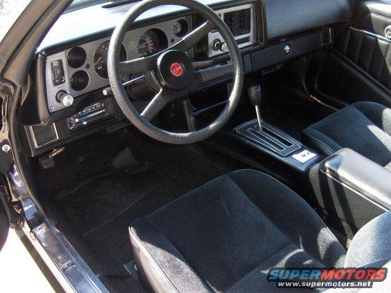 1979 Chevrolet Camaro interior with black cloth seats, a four-spoke steering wheel, and a center console with an automatic shifter