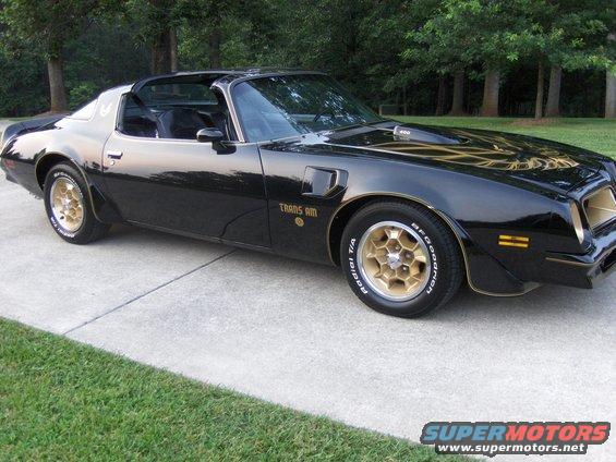 Black 1979 Pontiac Trans Am with gold trim and honeycomb wheels parked on a driveway
