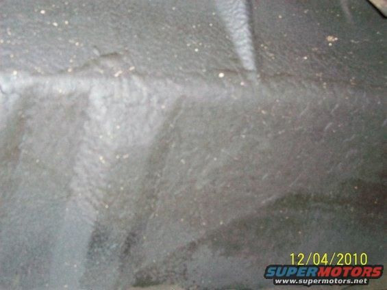 Gray interior floor mat with dirt specks and a white stripe