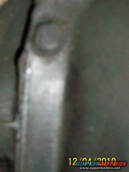 Close-up of a dark metal bracket with a bolt head visible, taken on 12/04/2010