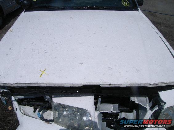 White car hood with yellow marks and damaged front end with exposed headlights