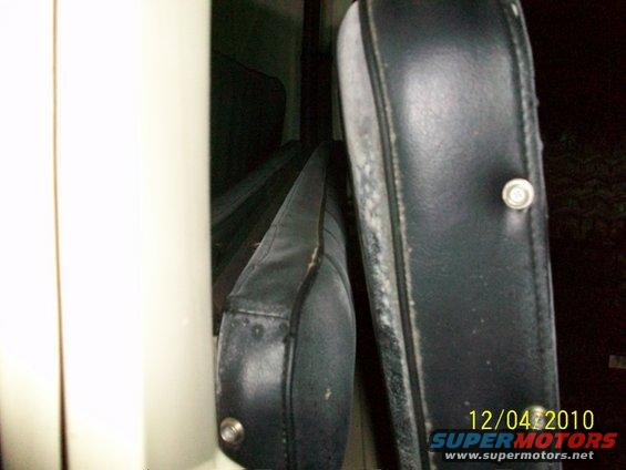 Interior view of black seats in a vehicle, showing wear and tear