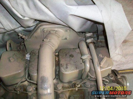 Engine block with hoses and a tarp covering part of it. Watermarks show 12/04/2010 and www.supermotors.net